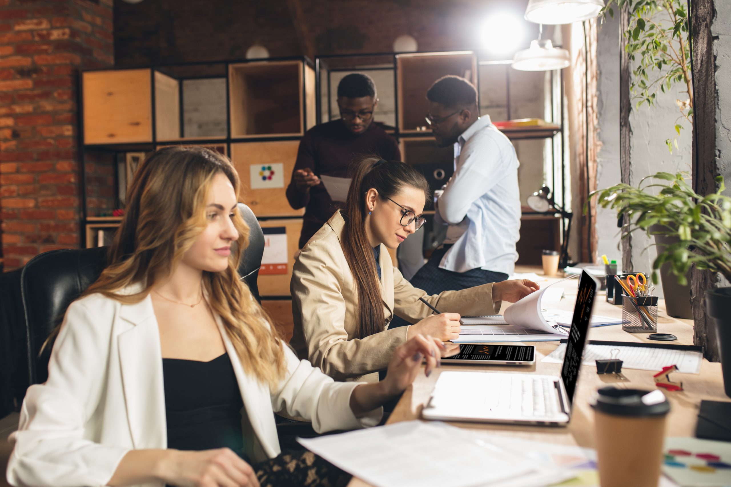 Processing. Colleagues working together in modern office using devices and gadgets during negotiations. Discussing, making decisions, routine tasks, projects. Successful corporate teamwork.